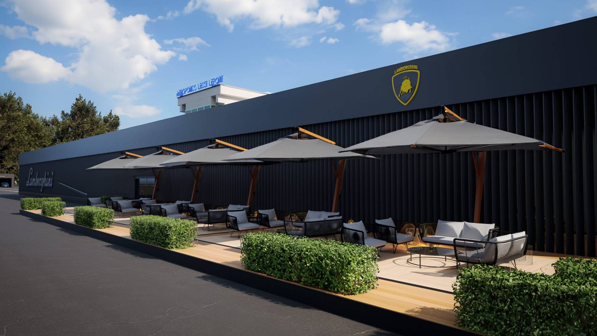 Area lounge esterna per l’evento “Dare to Live More” di Lamborghini, con eleganti postazioni relax dotate di grandi ombrelloni grigi, divanetti moderni e cespugli decorativi